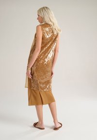 Un paio di capi sovrapposti: top dorato con paillettes sopra una gonna di satin marrone, lunga fino al ginocchio. Tessuto morbido, design senza maniche e vestibilità comoda.