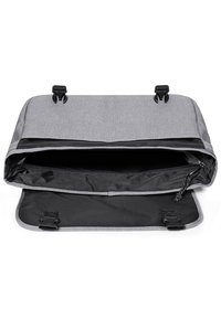 Borsa a tracolla grigia con tessuto testurizzato, interno nero e chiusura magnetica. L'interno presenta una tasca con zip e cinturini regolabili.