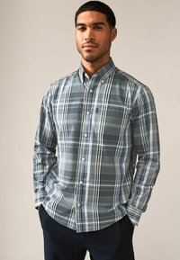 Langdrogige button-up shirt in donkerblauw en grijs geruit patroon, gemaakt van katoen met een enkele borstzak en een button-down kraag.