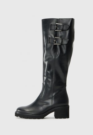 Black leather knee-high boot with a rounded toe, chunky heel, and two adjustable metal buckles on the calf. Smooth texture and sleek design.