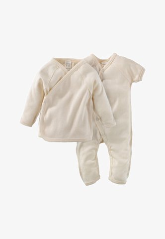 Two-piece infant clothing set in soft cream fabric. Includes a long-sleeve wrap top and full-length footed pants, both seamless and simple.