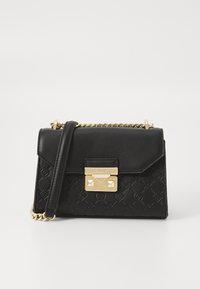 Borsa a mano in pelle nera con motivo in rilievo, hardware dorato, pattina pieghevole e tracolla a catena. Presenta borchie decorative sul fermaglio.