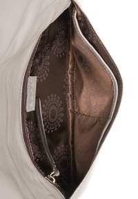 Světle šedý kožený interiér kabelky s hnědým vzorovaným podšívkou. Obsahuje kapsu na zip a hladkou texturu kolem okrajů.