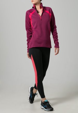 Top atletico zip-up color bordeaux con accenti rosa, abbinato a leggings neri con una striscia rosa; indossato con scarpe da corsa nere.