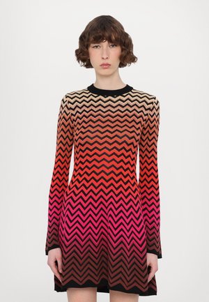 Knit dress with a chevron pattern gradient from beige to pink, long sleeves, and a black neck collar. Short, flared silhouette.