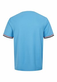 Jasnoniebieska koszulka z krótkim rękawem i okrągłym dekoltem. Posiada czarne, czerwone i białe paski na rękawach. Gładka, miękka tekstura materiału.