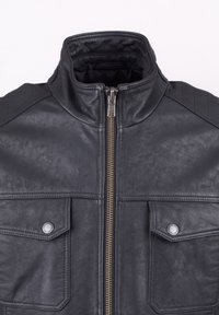 Black leather jacket with a high collar, zip closure, and two chest pockets. Features quilted shoulder accents and textured surface.