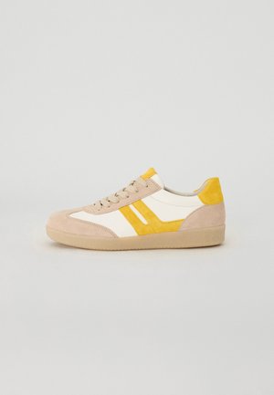 Beige Wildlederschuh mit weißen Lederpaneelen, gelben Akzenten und hellbraunem Gummisohle. Verfügt über eine runde Zehenpartie, Schnürdesign und strukturierte Oberfläche.