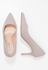 Spitze High Heels aus leicht beigem Textilmaterial mit einem Ausschnitt-Design, geschlossenem Absatz und schlanken Absätzen.