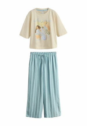 Béžová košeľa s krátkym rukávom a potlačou abstraktnej maľby v kombinácii so svetlomodrými a sivými pruhmi na širokých nohaviciach s elastickým pásom a šnúrkou.