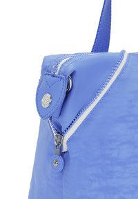 Jasnoniebieska torba nylonowa z srebrnym zamkiem błyskawicznym, skórzanym akcentem i przyciskiem z logo. Wyposażona w mocną rączkę oraz gładką, fakturowaną powierzchnię.