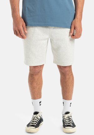 Light gray cotton shorts with a relaxed fit, feature an elastic waistband and side pockets, paired with black canvas sneakers and white socks.