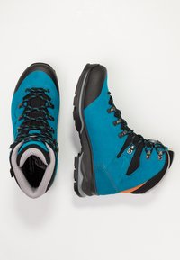 Blaue und schwarze Wanderschuhe mit Obermaterial aus Wildleder, Gummizehenkappe und Metall-Schnürhaken. Strukturierten Sohlen für Traktion und Langlebigkeit.