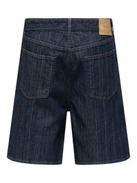 Short en jean bleu foncé avec des rayures blanches verticales, deux poches arrière, passants pour ceinture et un écusson de marque en cuir beige sur la taille.