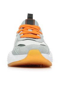 Scarpa sportiva grigia con lacci arancioni, dotata di un upper in suede testurizzato, colletto imbottito e una suola intermedia bianca con una suola esterna arancione.