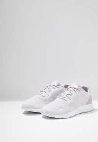 Chaussures de sport légères avec une tige en mesh respirant de couleur violette pâle, design à lacets blancs et semelle texturée. Talon renforcé pour un meilleur soutien.