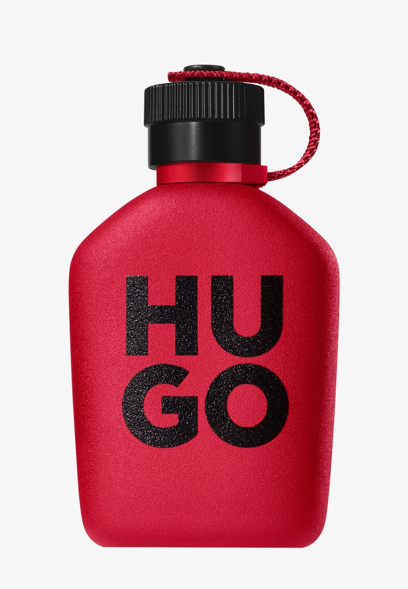 Roter flaschenförmiger Behälter mit schwarzem Schraubverschluss und rotem Riemen, mit fettem schwarzen "HUGO"-Schriftzug auf der Vorderseite.