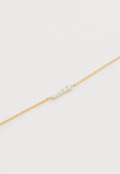 Brățară cu lanț auriu, având un accent curbat din argint cu mici rhinestones încrustate, evidențiind contrastul între materiale și texturi.