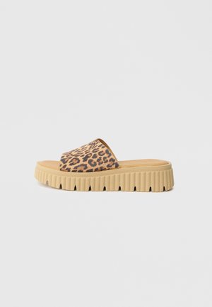 Leopard print slide sandal with a beige cushioned insole and chunky, textured tan platform sole featuring grooves.