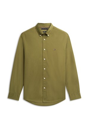 Alievu žalia marškinėliai su ilgomis rankovėmis, apykakle ir baltais mygtukais. Kairėje krūtinės pusėje yra mažas logotipas.