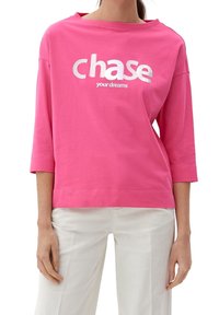 Rosa bomullströja med avspänd passform, 3/4 ärmar och bred rund halsringning. Har vit text: "jaga dina drömmar" i fet stil.