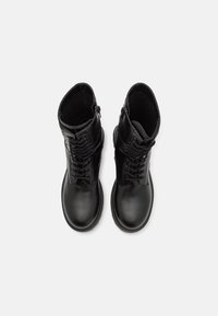 Mustad nahast pahkluu saapad ümmarguse nina, nööridega disain ja külgne tõmblukk. Sile tekstuur koos peene õmblemise detailiga.