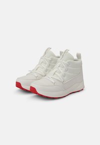 Scarpe alte bianche con upper in rete, lacci bianchi e suola in gomma rossa. Presenta il logo sulla linguetta e un passante sul tallone.