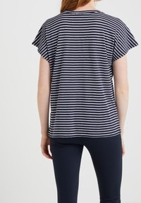 Marineblauw en witte gestreepte T-shirt met korte vluchtige mouwen, met een losse pasvorm en ronde halslijn, gemaakt van lichtgewicht stof.