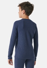 Navy long-sleeve shirt made of soft fabric, featuring a round neckline, fitted sleeves, and a smooth texture. Rear view shows clean lines.