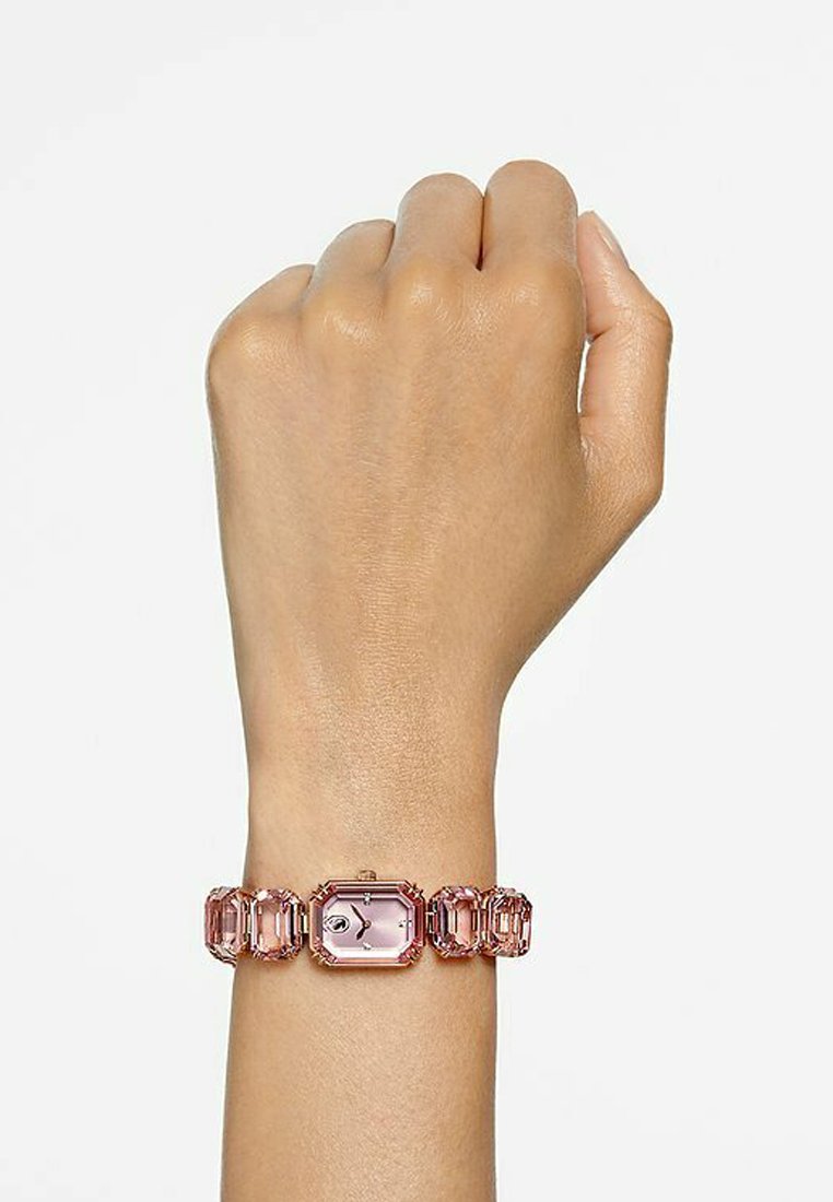 Reloj rectangular rosa con una correa transparente y facetada. La carátula tiene tres agujas y una pequeña esfera. Los toques metálicos brillantes realzan el diseño.