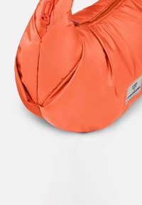 Borsa arancione imbottita con una finitura satinata liscia, forma ergonomica e chiusura con zip nella parte superiore. Presenta un'etichetta sul lato.