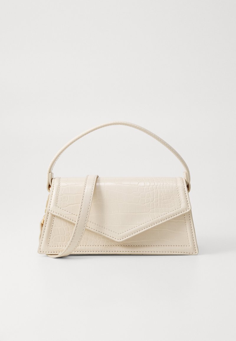 Petit sac à main beige avec texture crocodile, rabat triangulaire, poignée supérieure et bandoulière amovible sur fond uni.