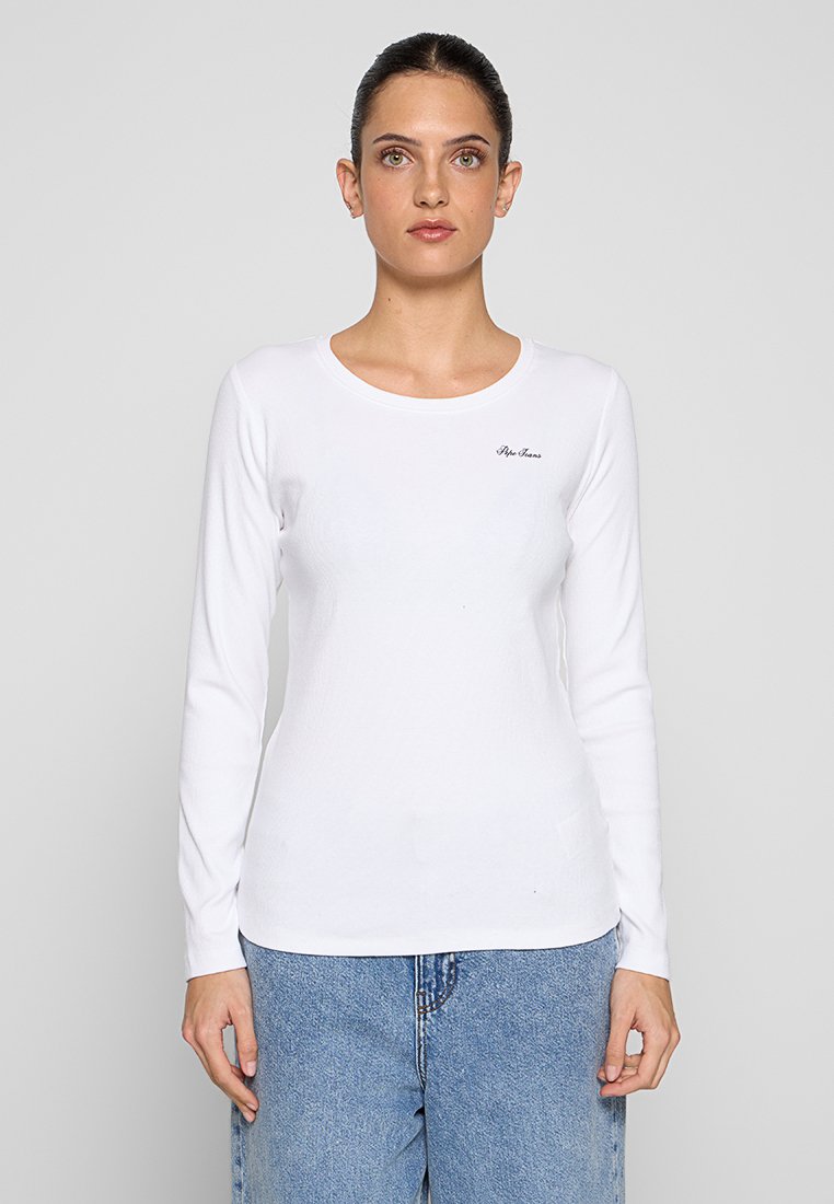 Chemise blanche à manches longues avec un col rond et un logo discret en haut à gauche. Elle présente une texture douce et lisse et un design ajusté.