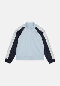 Hele sinine jooksujakk tumesiniste varrukatega, valged ševroontriibud varrukatel, täielik eesmine tõmblukk ja väike tikitud logo rinnal.