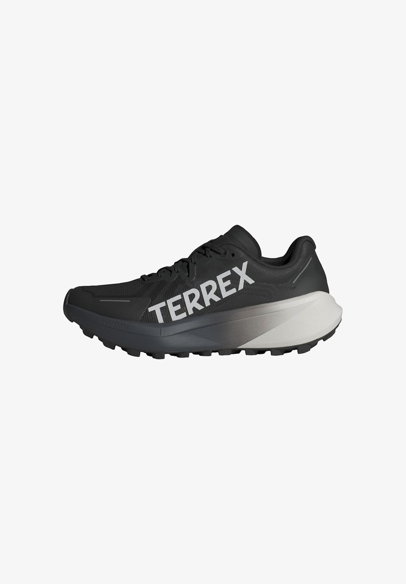 Czarny i szary but do biegania po szlaku z grubą podeszwą i logo "TERREX" w dużych białych literach z boku.