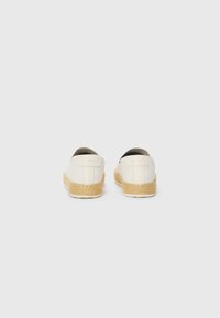 Espadrilles with a cream canvas upper and woven jute sole. Rounded shape with a slip-on design and minimal branding on the heel.