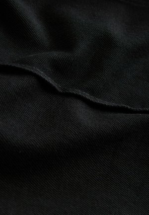 Schwarzer Stoff mit glatter Textur und subtiler diagonaler Rippung, mit einem gefalteten Saum und minimalem Glanz.
