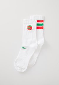 Chaussettes blanches avec une broderie de tomate rouge et un bandeau rayé coloré en rouge, vert et blanc. Texte "FORTNITE" en vert sur le côté.