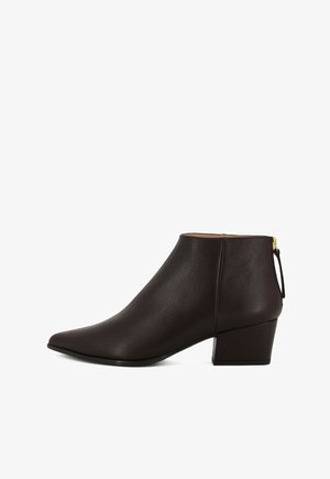 Stivale alla caviglia in pelle marrone con punta affusolata e tacco a blocco piccolo. Presenta una chiusura con cerniera e un tab di trazione sul retro per indossarlo facilmente.