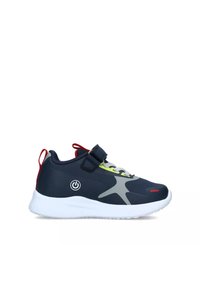 Scarpe sportive blu navy con suola bianca, dotate di una cintura in velcro, accenti grigi e lacci giallo fluo. Dettaglio del simbolo di potenza vicino al tallone.