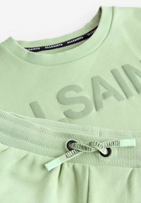 Lysgrøn sweatshirt og shorts sæt i bomuld. Sweatshirten har ophævet "ALLSAINTS" tekst; shortsen har en tekstureret talje og snøre.