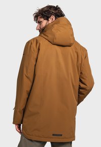Brown waterproof jacket with a hood, featuring a smooth texture, simple design, and a logo label at the hem. Shows rear view.