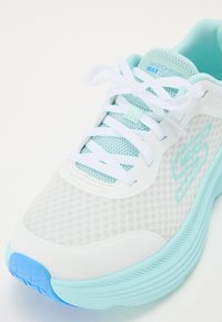 Weißer Laufschuh mit Mesh-Obermaterial, hellblauen Akzenten und dicker Sohle. Verfügt über weiße Schnürsenkel, Dämpfung und eine strukturierte blaue Außensohle.