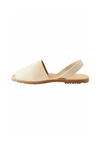 Sandal in pelle beige con design a punta aperta, cinturino regolabile e suola in gomma testurizzata per una migliore aderenza. Stile semplice e minimalista.