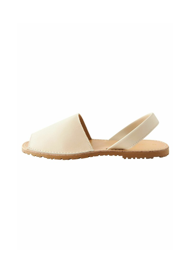 Sandal in pelle beige con design a punta aperta, cinturino regolabile e suola in gomma testurizzata per una migliore aderenza. Stile semplice e minimalista.