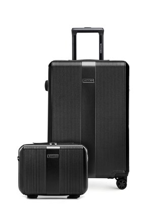 Valigia grande rigida nera con superficie testurizzata, quattro ruote e manico telescopico, accompagnata da una valigetta più piccola abbinata per il bagaglio a mano.