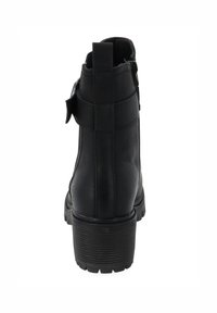Botín negro hasta el tobillo con un exterior de cuero texturizado, suela de goma resistente y cremallera lateral. Presenta un lazo trasero y acentos mínimos.
