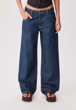 Wide-leg dark blue denim jeans with a high waist, front pockets, and contrasting orange stitching. Smooth texture, relaxed fit.