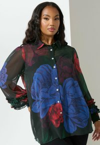 Camicia nera trasparente con grandi stampe floreali blu e rosse, bottoni frontali, colletto e polsini arricciati, realizzata in tessuto leggero.