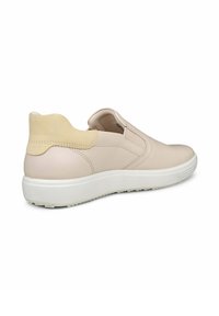 Scarpe slip-on beige con tomaia in pelle liscia, linguetta posteriore in suede giallo testurizzato e suola in gomma bianca con motivi antiscivolo.